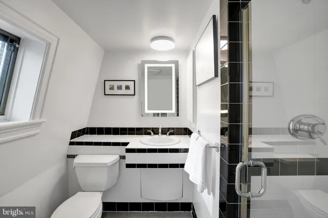 a bathroom with a toilet sink and mirror