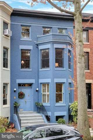 a front view of a building with a garden and plants