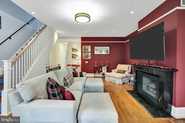 a living room with furniture a flat screen tv and a fireplace