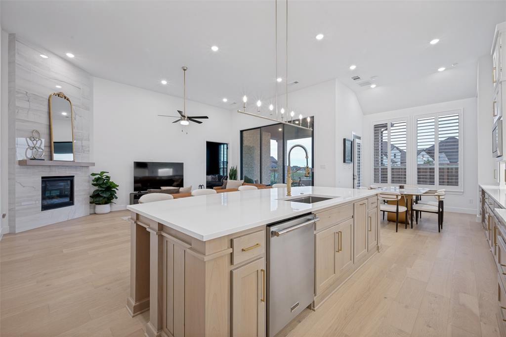 4400 Meander Way Prosper, TX 75078 - Photo 13 of 40 a large kitchen with kitchen island a sink table and chairs