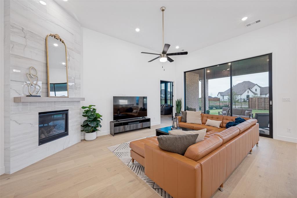 4400 Meander Way Prosper, TX 75078 - Photo 10 of 40 a living room with furniture a fireplace and a flat screen tv