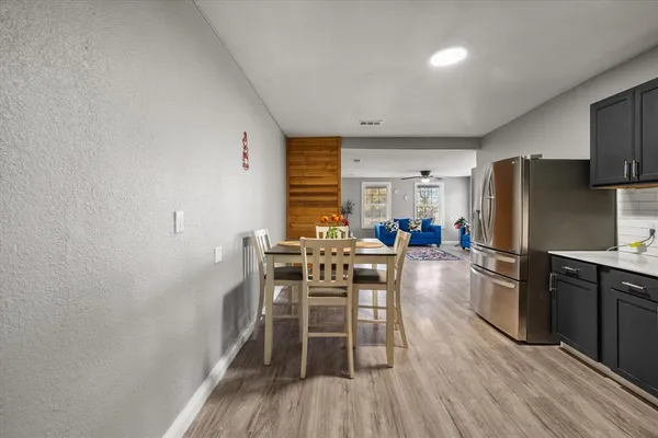 a kitchen with stainless steel appliances a dining table chairs stove and refrigerator