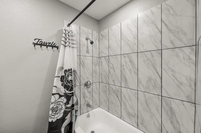 a bathroom with a bathtub and shower