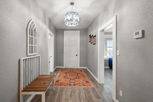 a view of a hallway with wooden floor and a livingroom