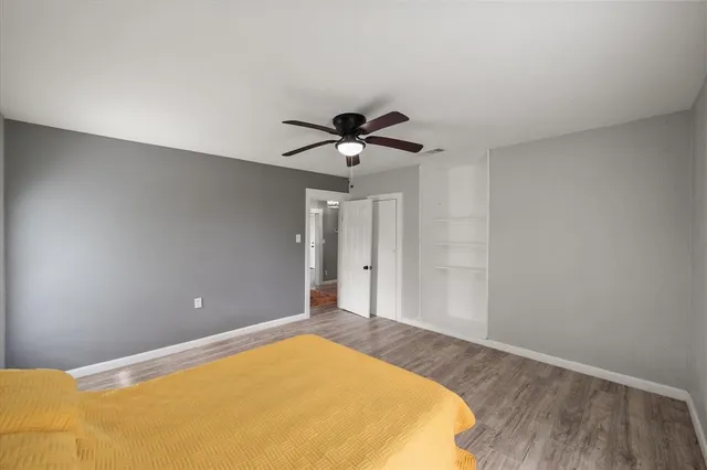 a view of a room with a ceiling fan and wooden floor