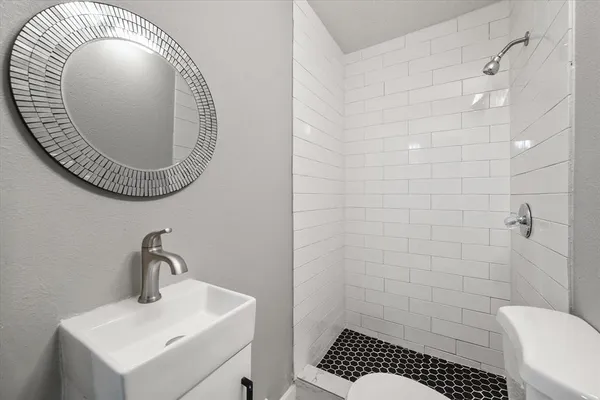 a bathroom with a toilet a sink and mirror