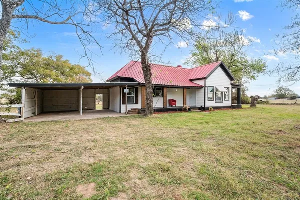 a front view of a house with a garden and trees