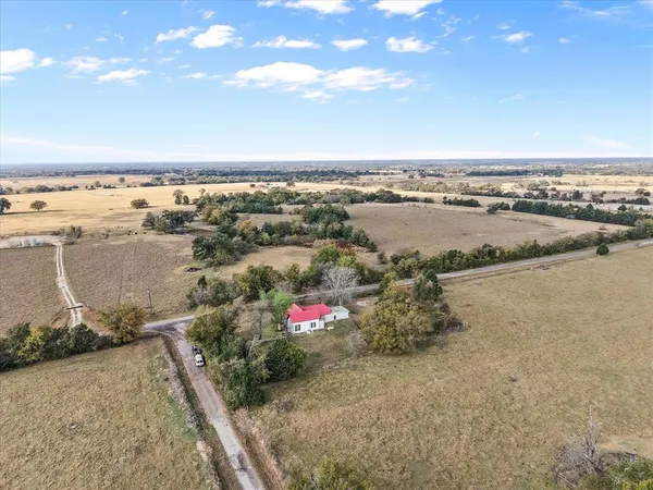 an aerial view of ocean and residential houses with outdoor space
