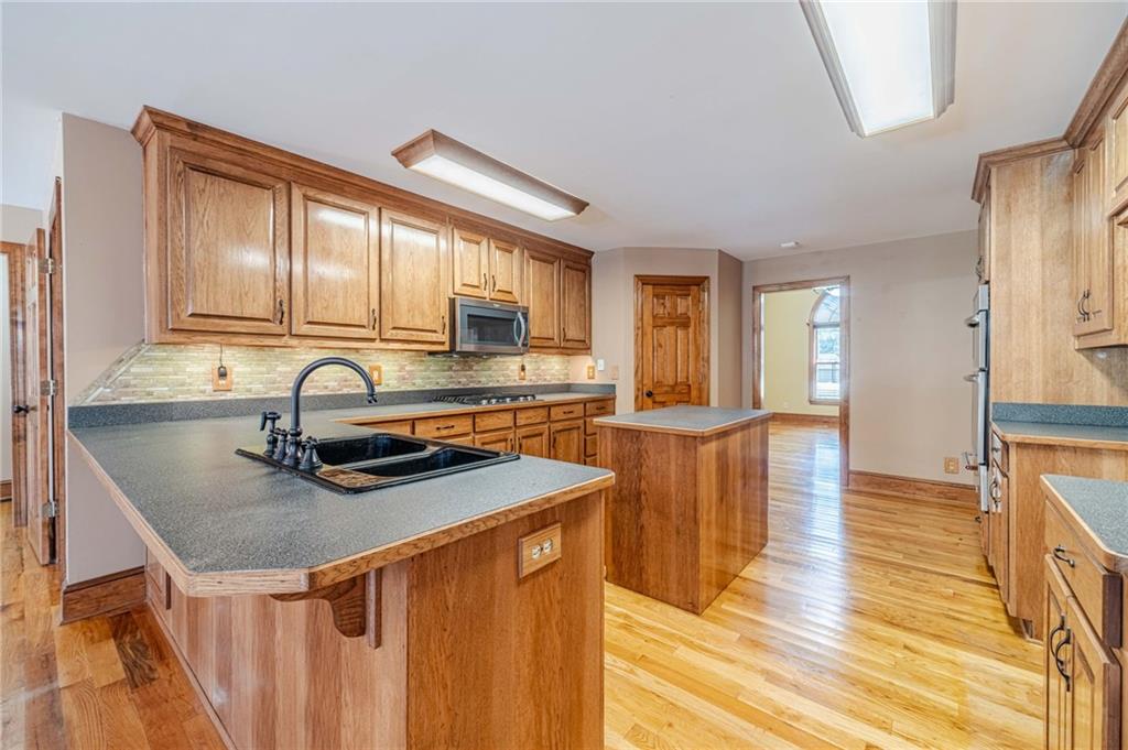 2705 Luke Edwards Road Dacula, GA 30019 - Photo 29 of 74 a kitchen with stainless steel appliances granite countertop a sink a stove top oven a counter space and cabinets