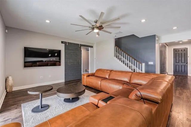 a living room with furniture a flat screen tv and kitchen view