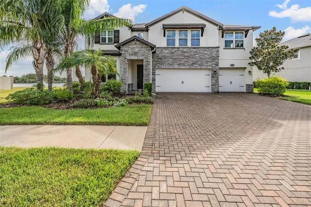 a front view of a house with a garden and trees