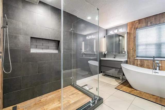 a bedroom with a bed a dresser and wooden floor