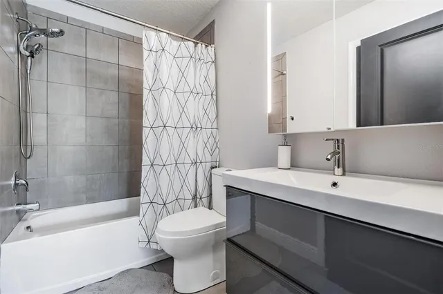 a bedroom with a bed a couch and a potted plant