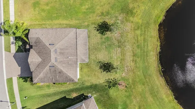a front view of house with yard and trees in the background