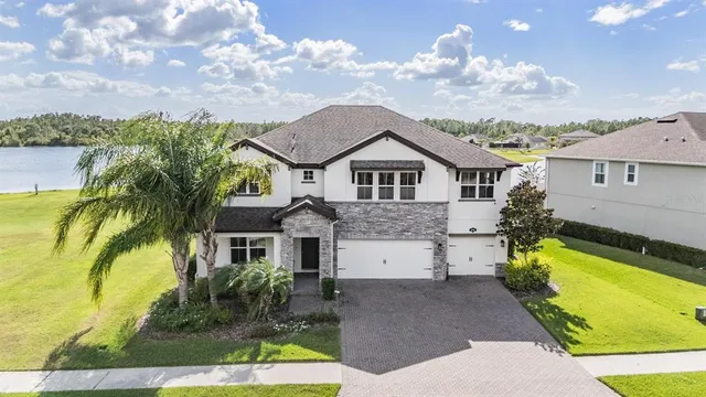 an aerial view of a house with a garden and lake view
