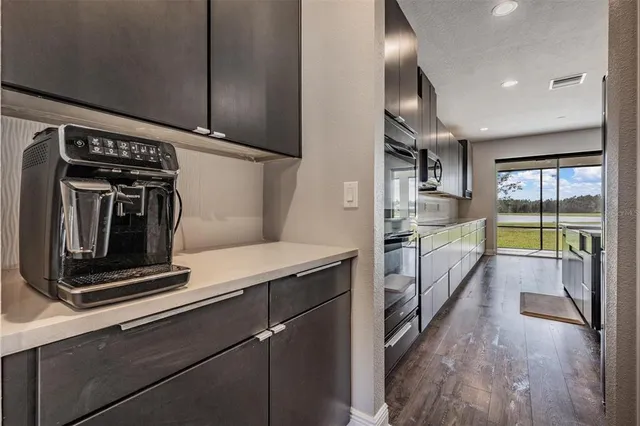 a kitchen with kitchen island a counter top space a sink stainless steel appliances and cabinets