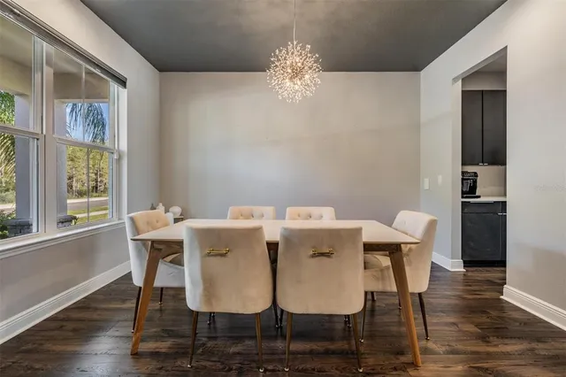 a dining room with furniture a chandelier and wooden floor