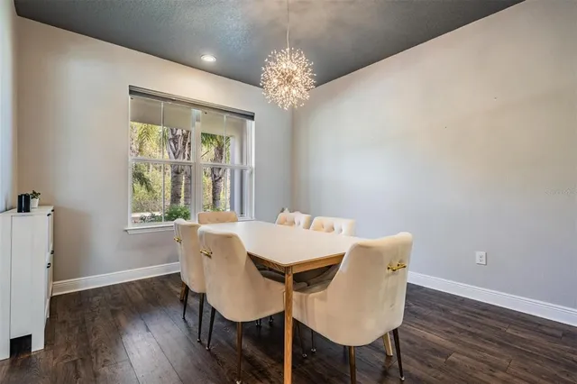 a view of a dining room with furniture a chandelier and wooden floor
