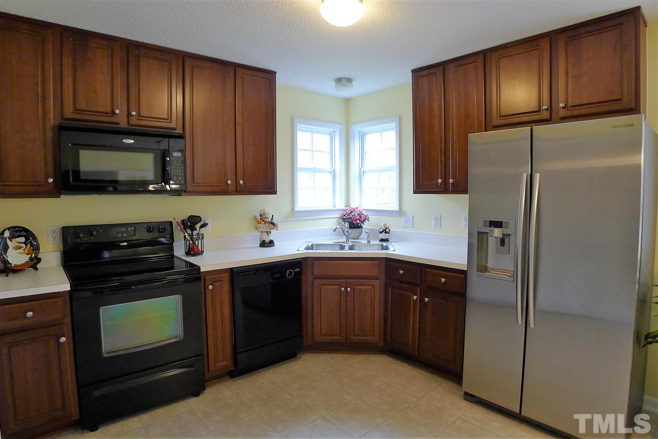 208 Muirfield Ridge Drive Garner, NC 27529 - Photo 12 of 30 a kitchen with a sink stove and refrigerator