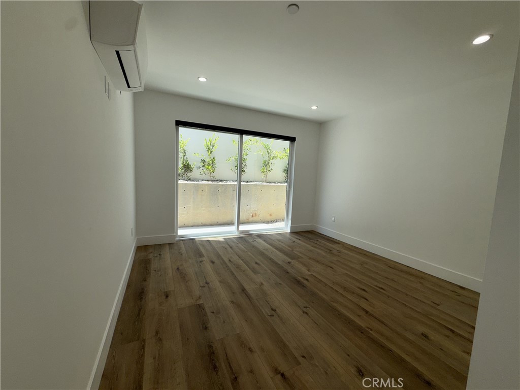 4454 Clinton Street, Unit 1/2 Los Angeles, CA 90004 - Photo 11 of 12 an empty room with wooden floor and windows
