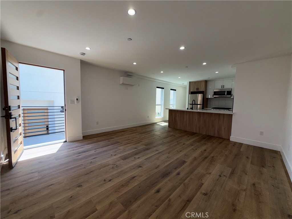 4454 Clinton Street, Unit 1/2 Los Angeles, CA 90004 - Photo 6 of 12 an empty room with wooden floor and windows