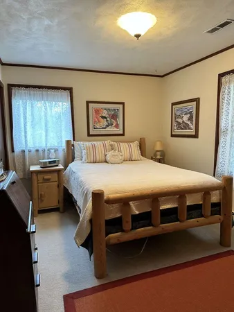 a bedroom with a bed and a painting on the wall
