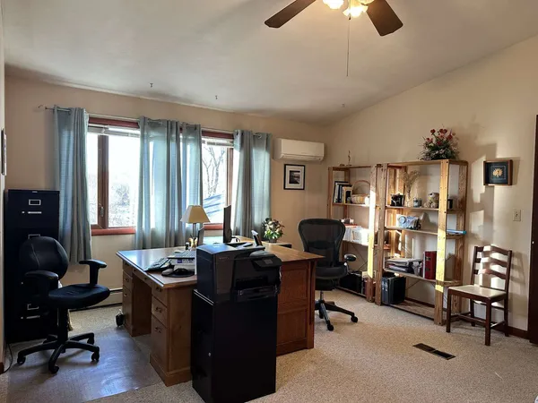 a view of a livingroom with workspace and a window