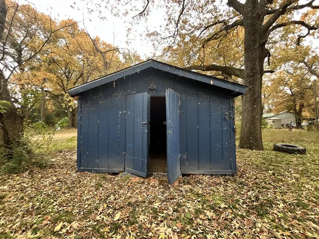 a wooden house with a large tree in front of it