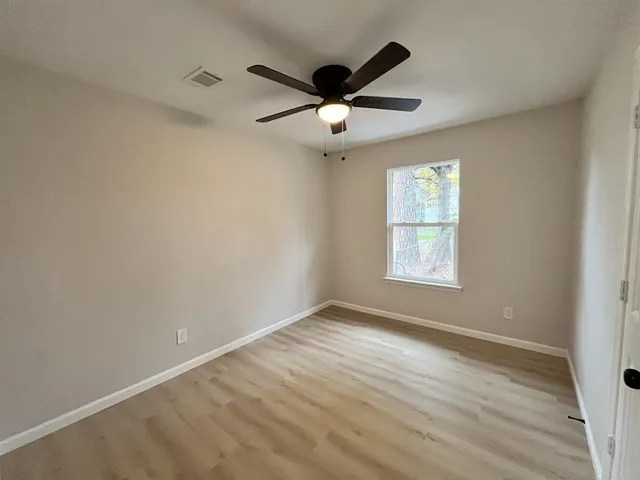 wooden floor in an empty room with a window
