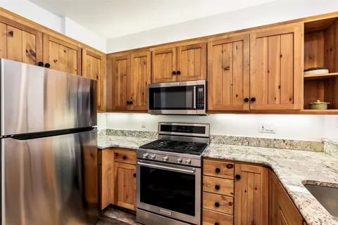a kitchen with granite countertop a refrigerator stove and microwave
