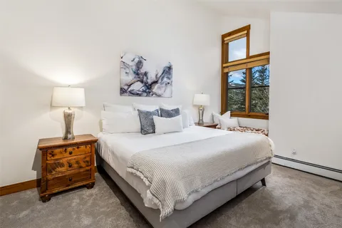 a bedroom with a bed and a painting on the wall