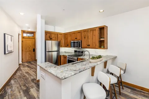 a kitchen with stainless steel appliances granite countertop a sink and a refrigerator