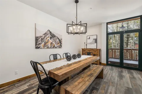 a dining room with furniture a chandelier and wooden floor