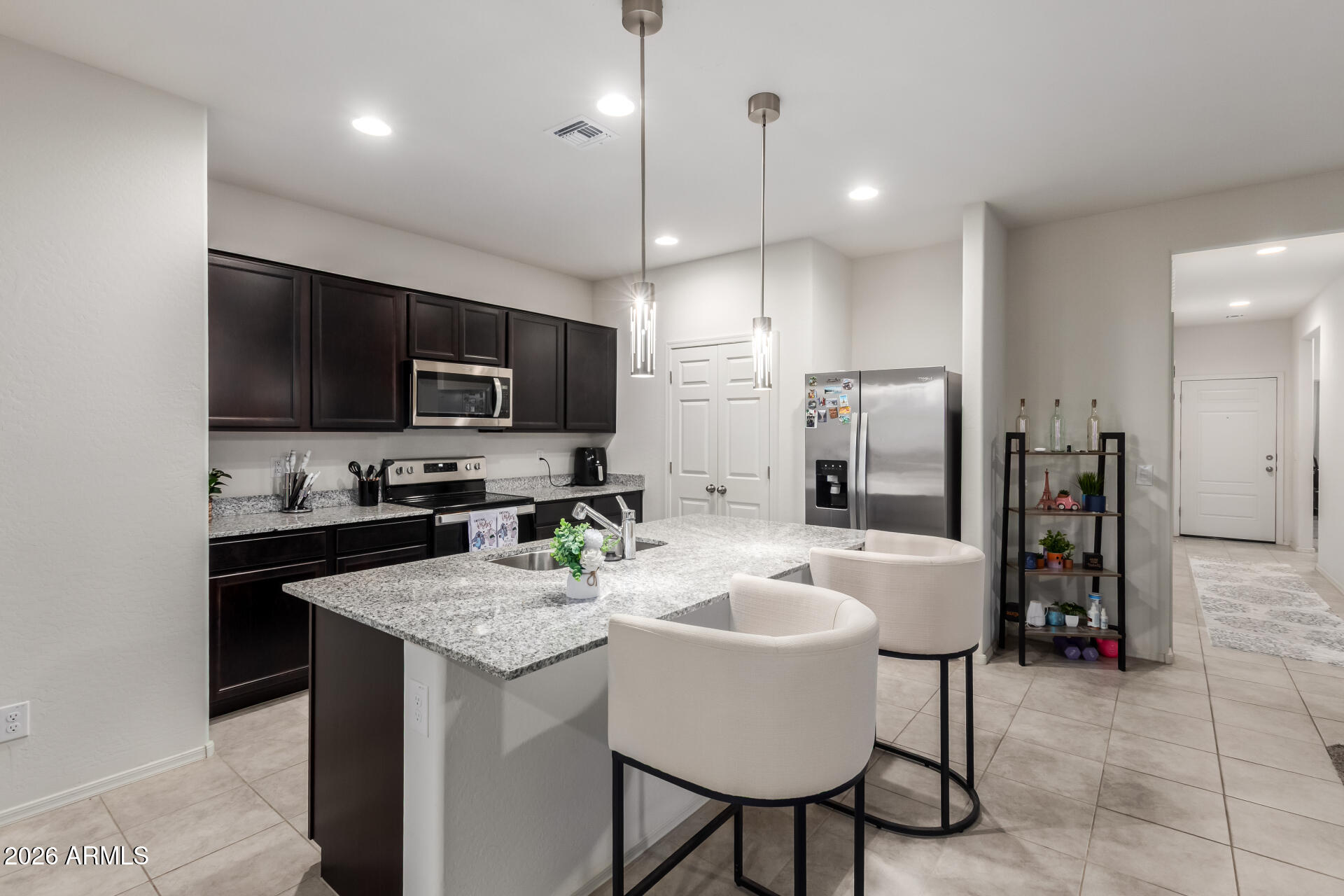 11214 West Bloch Road Tolleson, AZ 85353 - Photo 6 of 24 a kitchen with a refrigerator a stove a sink and chairs