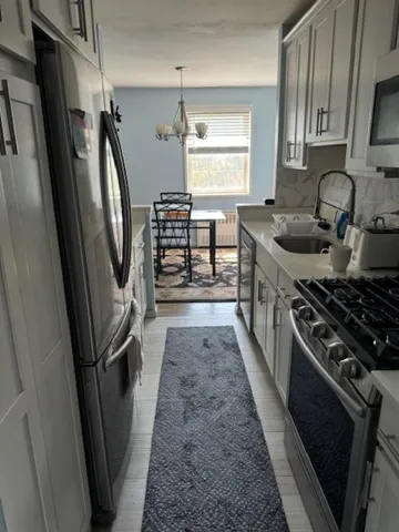 a kitchen with granite countertop a sink stove and refrigerator