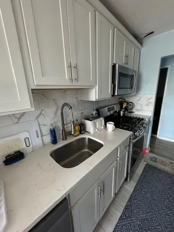 a kitchen with stainless steel appliances a sink a stove and microwave
