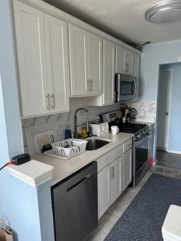 a kitchen with stainless steel appliances granite countertop a sink a stove a microwave and cabinets