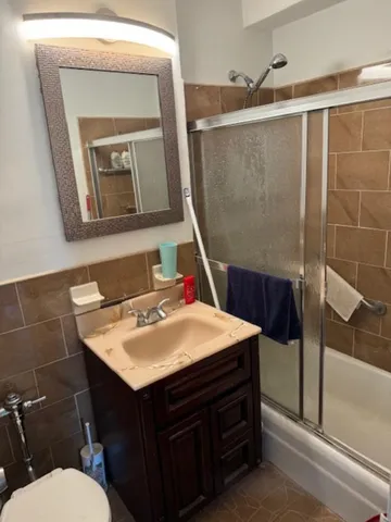 a bathroom with a sink vanity mirror and toilet