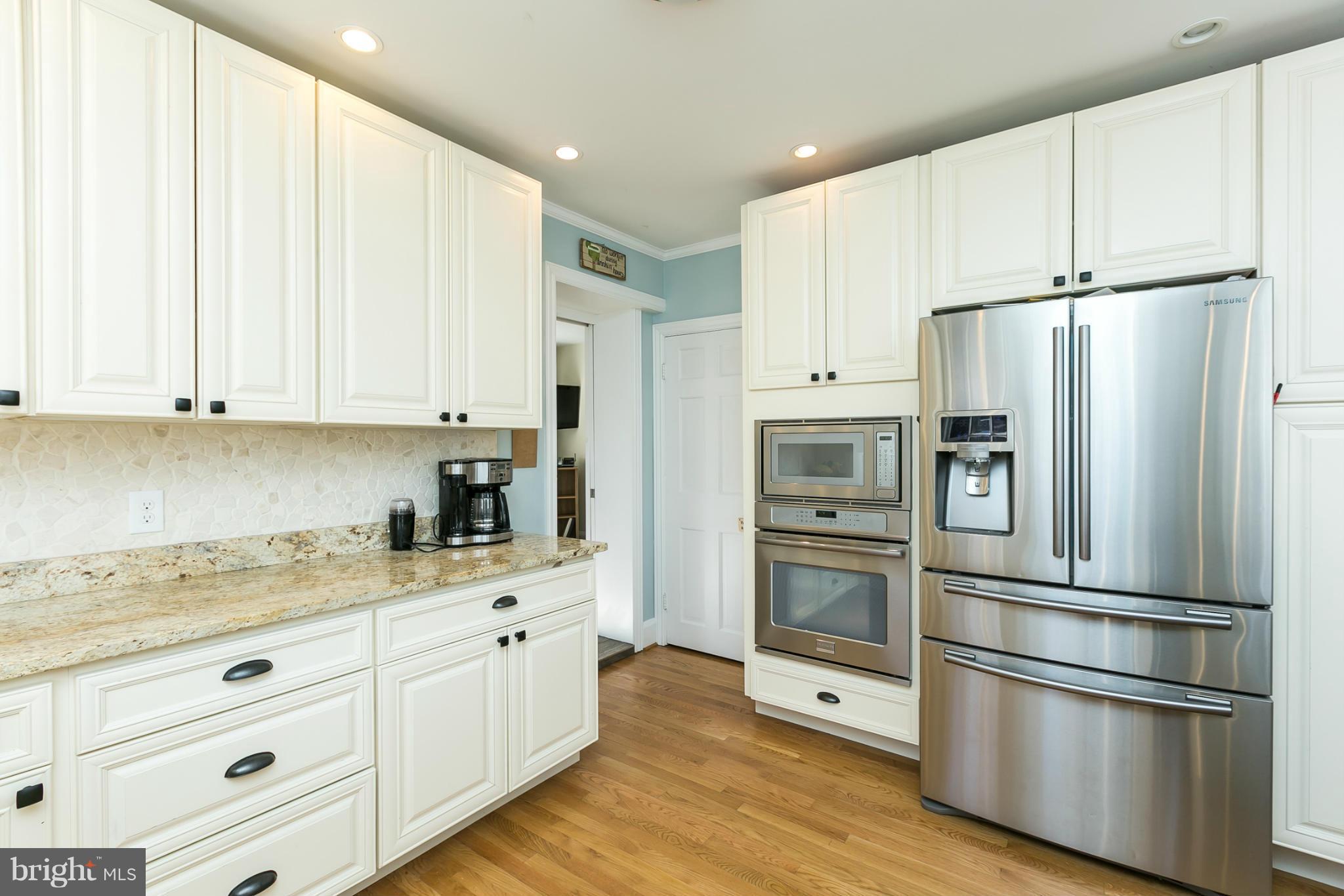 611 Wilton Road Towson, MD 21286 - Photo 5 of 30 a kitchen with cabinets stainless steel appliances and wooden floor