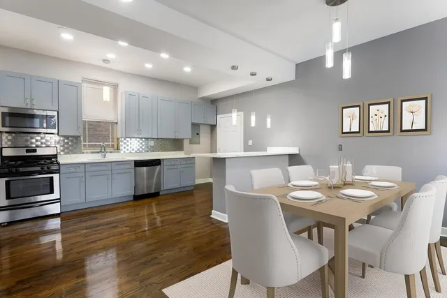 a kitchen with a table chairs microwave and cabinets