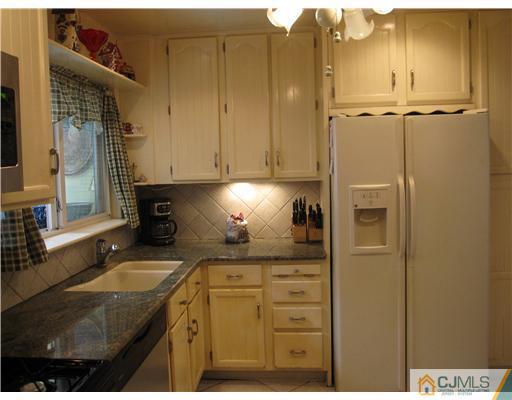 23 Phillips Road Edison, NJ 08817 - Photo 5 of 12 a kitchen with granite countertop a sink and a stove