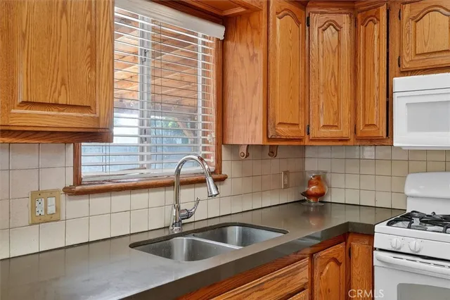 a kitchen with stainless steel appliances a sink a window and cabinets