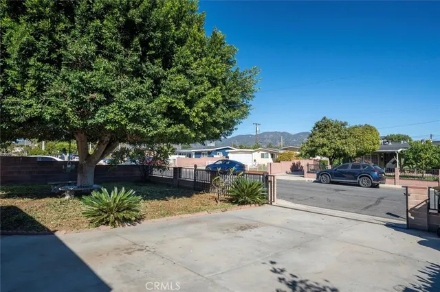 a view of a garden with a bench in front of a house