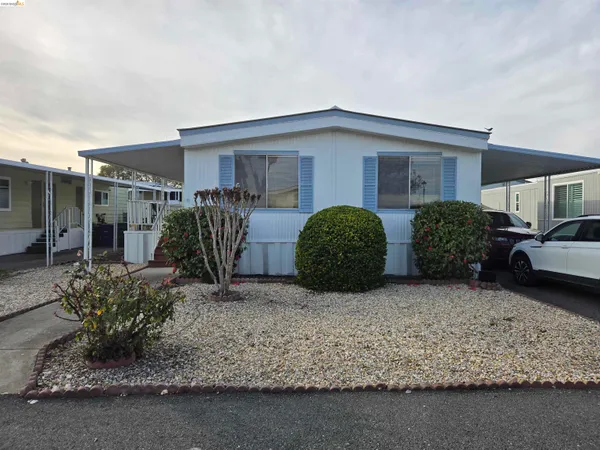 a view of a house with a yard and lawn chairs