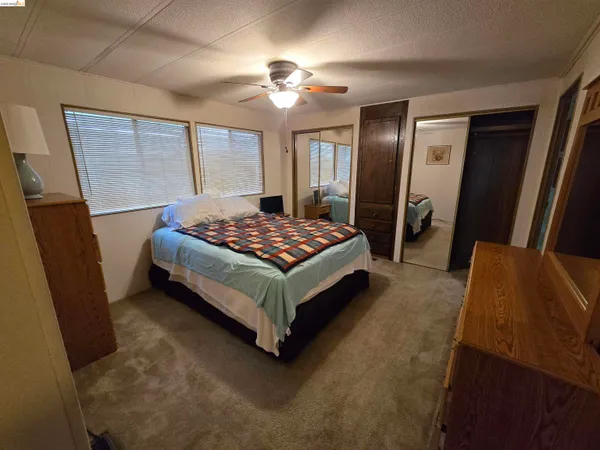 a spacious bedroom with a bed and a chandelier