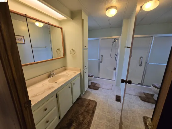 a bathroom with a double vanity sink and mirror with shower