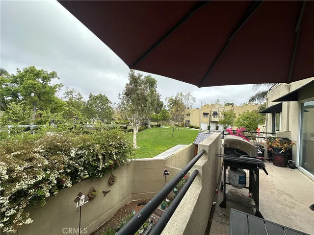 a view of a roof deck with table and chairs under an umbrella
