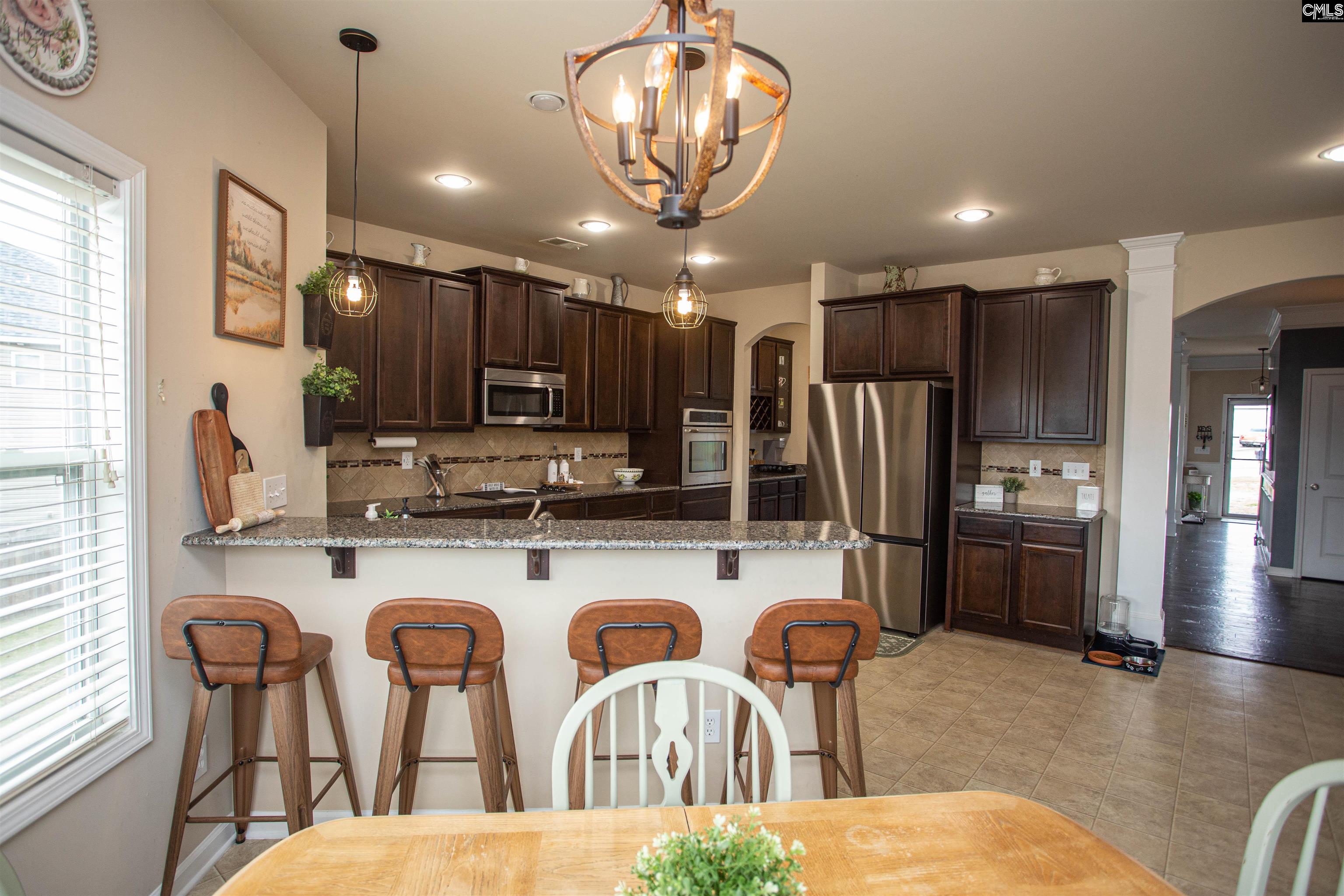 7 Templand Court Elgin, SC 29045 - Photo 13 of 47 a kitchen with lots of counter space dining table and stainless steel appliances