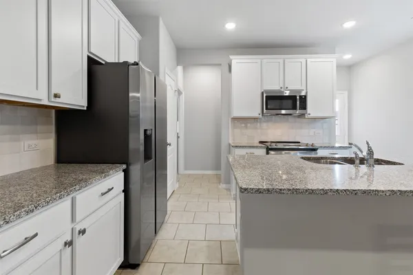 a kitchen with stainless steel appliances granite countertop a sink a stove and cabinets