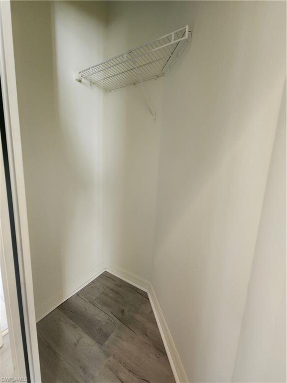 14708 Sutherland Avenue Naples, FL 34119 - Photo 12 of 24 Walk in closet with dark wood-style floors